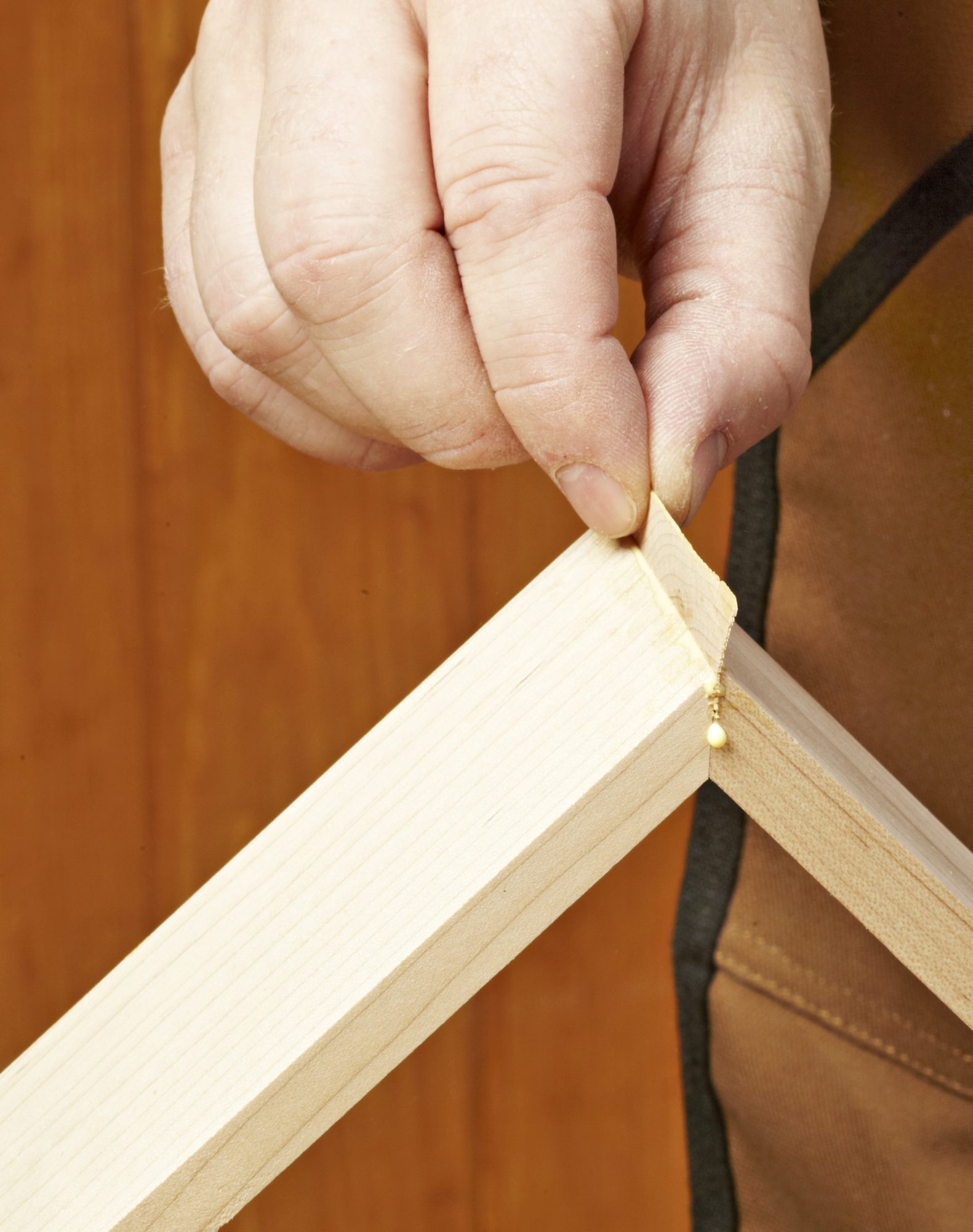 Photo of hand inserting sliver into miter joint gap