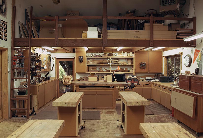 Inside of shop. Two major work benches, cabinets all around shop.